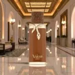 Parfum unisex Vulcan Sable de la French Avenue 100ml, flacon cilindric maro ciocolatiu cu ornament auriu în formă de șarpe.